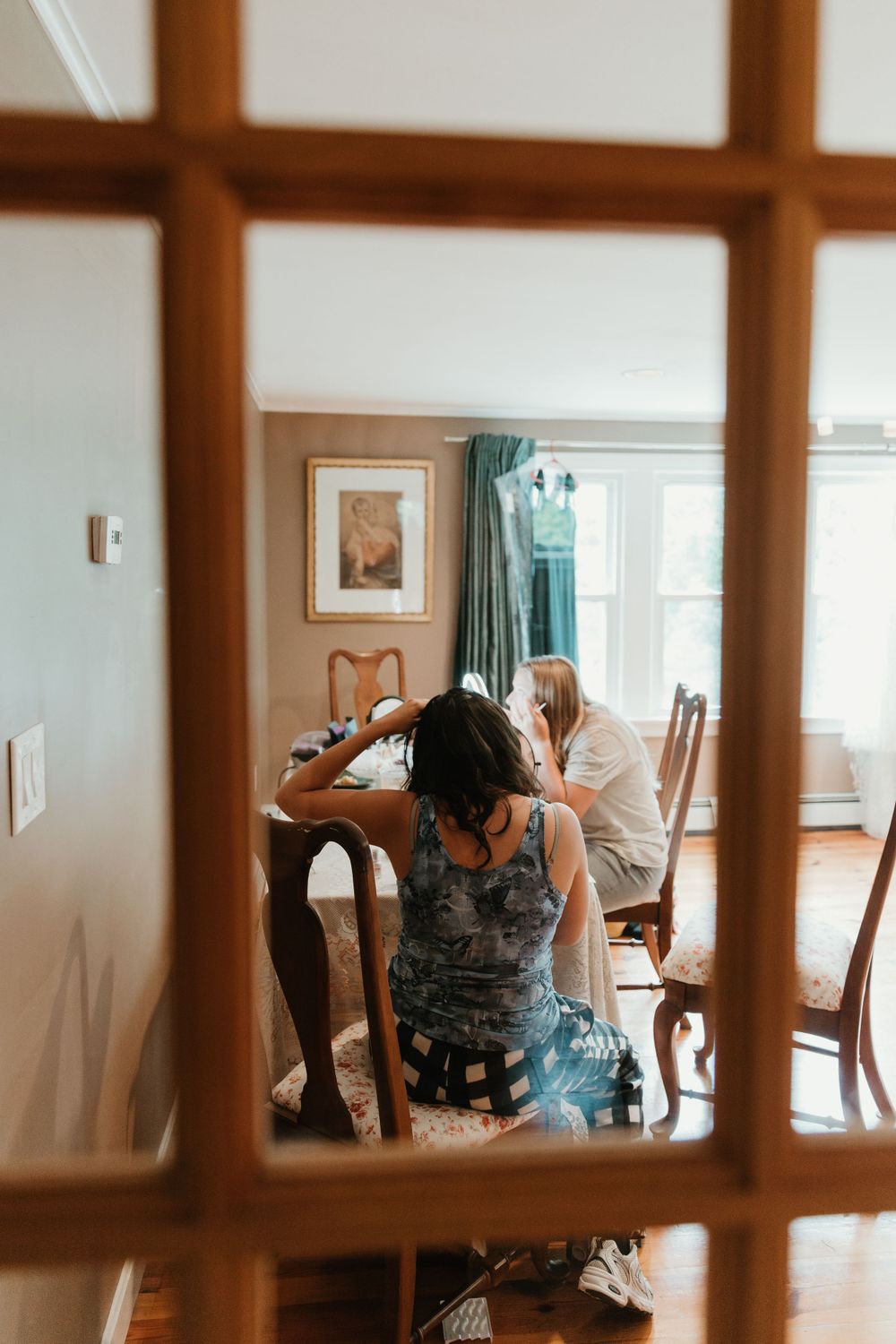 Blurred view through wooden window panes of wedding preparation activities.