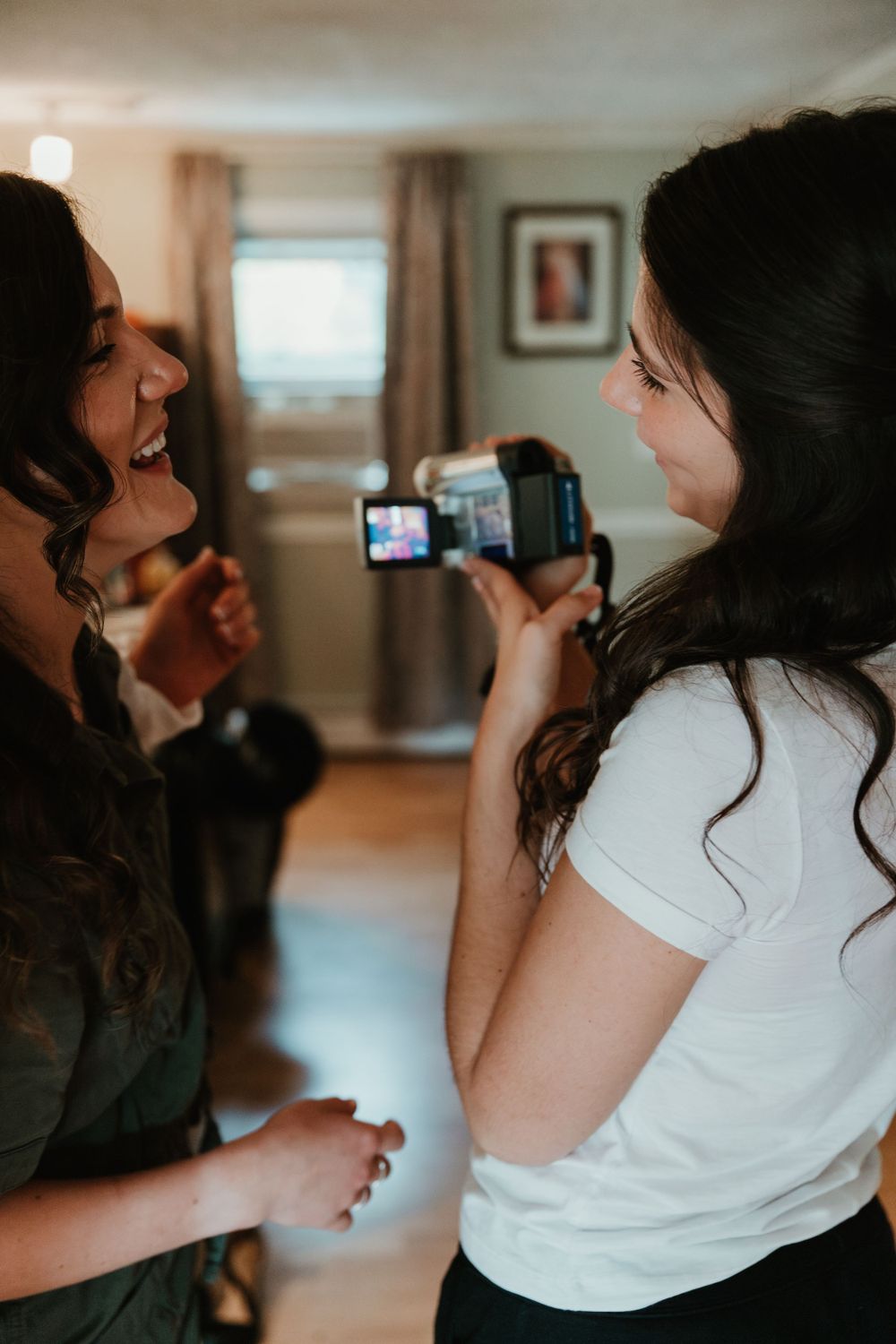 Behind-the-scenes shot of videographer capturing wedding day preparations.