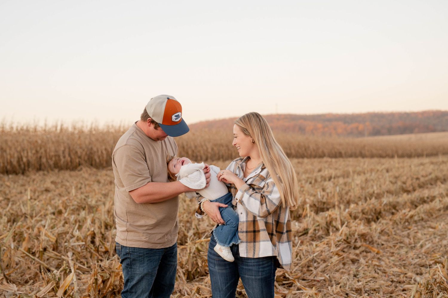 Family sharing a special moment in front of farm equipment during harvest season.