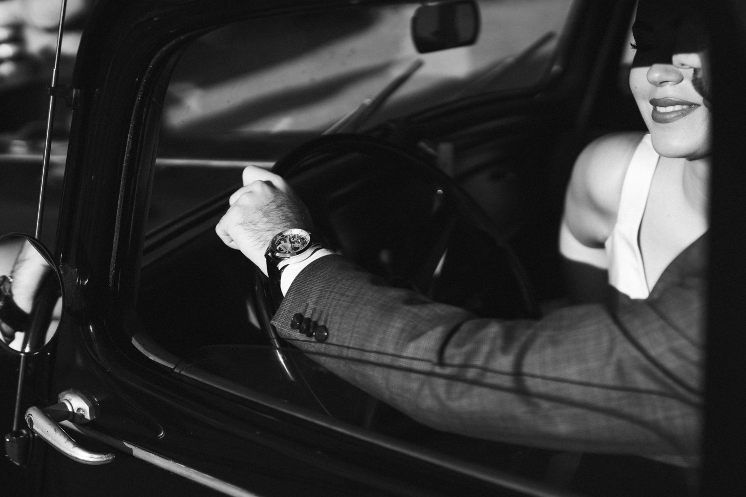 Black and white close-up view through a car window showing elegant wedding attire. next day wedding photoshoot.