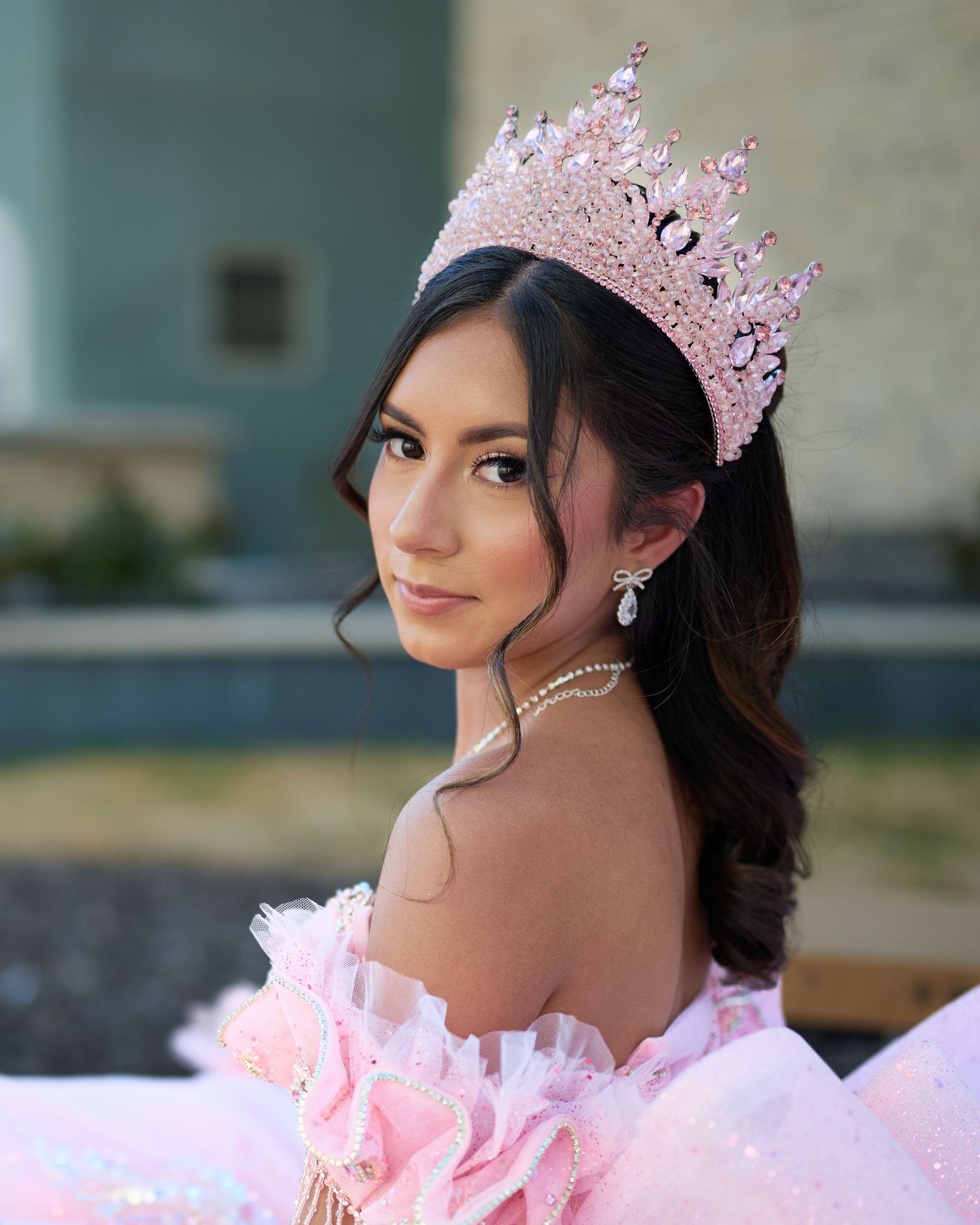 A person wearing an ornate pink crown and formal attire in multiple portrait style poses.