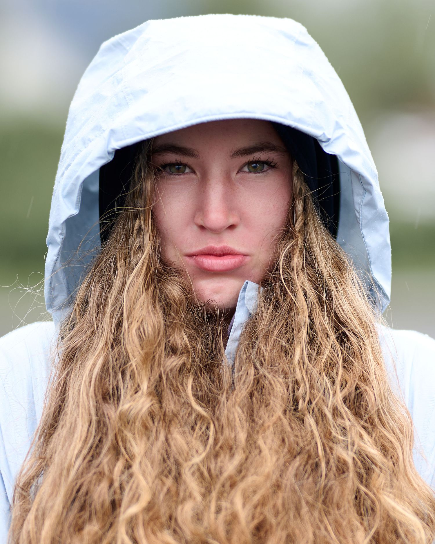 Closeup photos of someone wearing a white sun hat with wavy blonde hair framing their face in multiple similar poses.