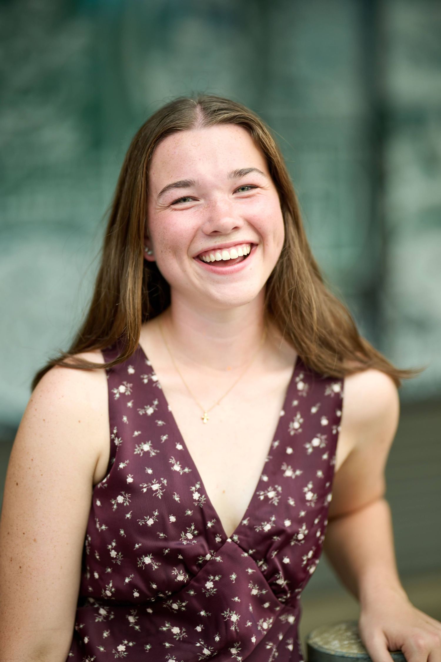 A joyful expression captured in a portrait featuring a purple floral dress against a soft bokeh background.
