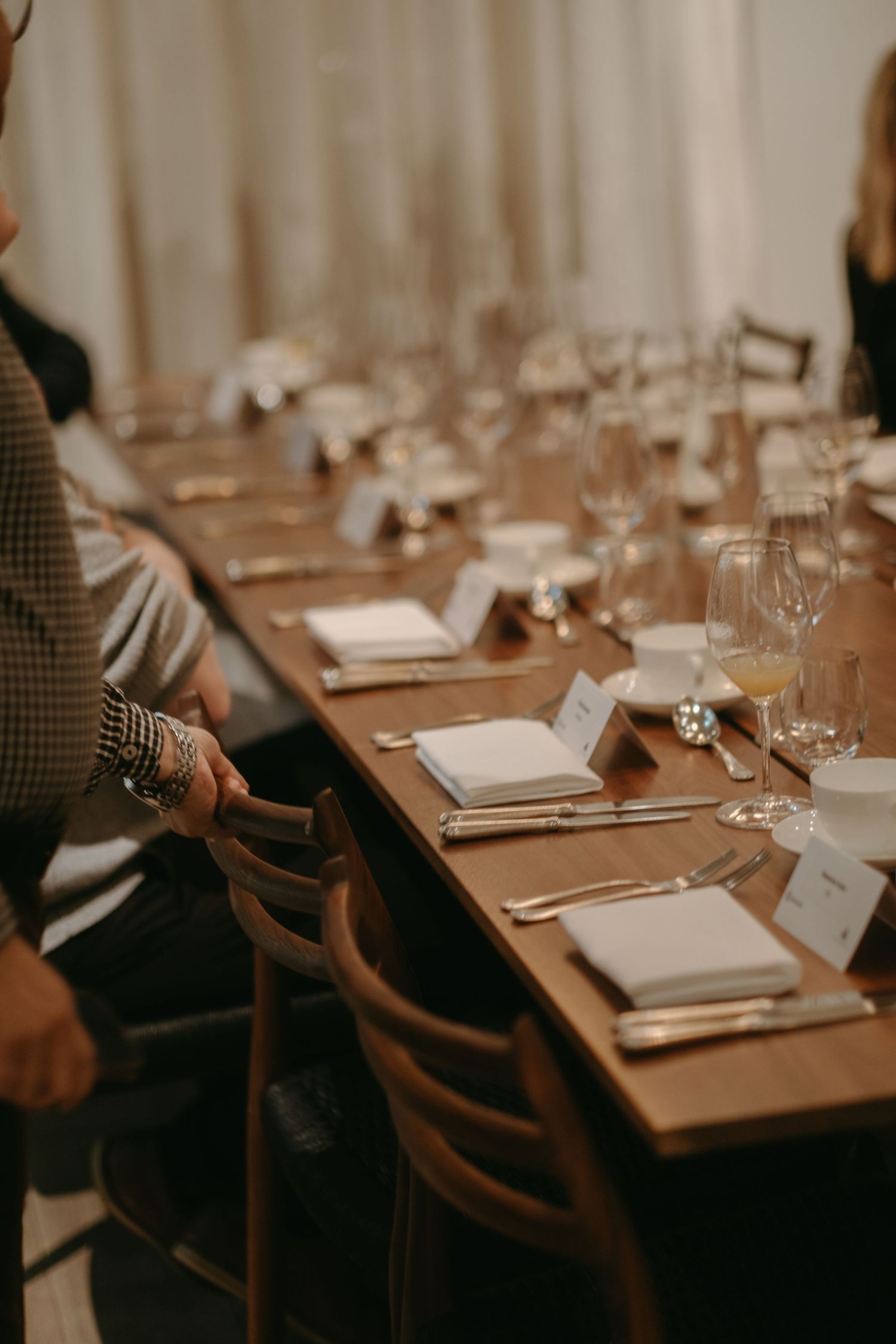 detail of a man's hand grabbing a chair by a lunch table while being captured by event photographer in Stockholm