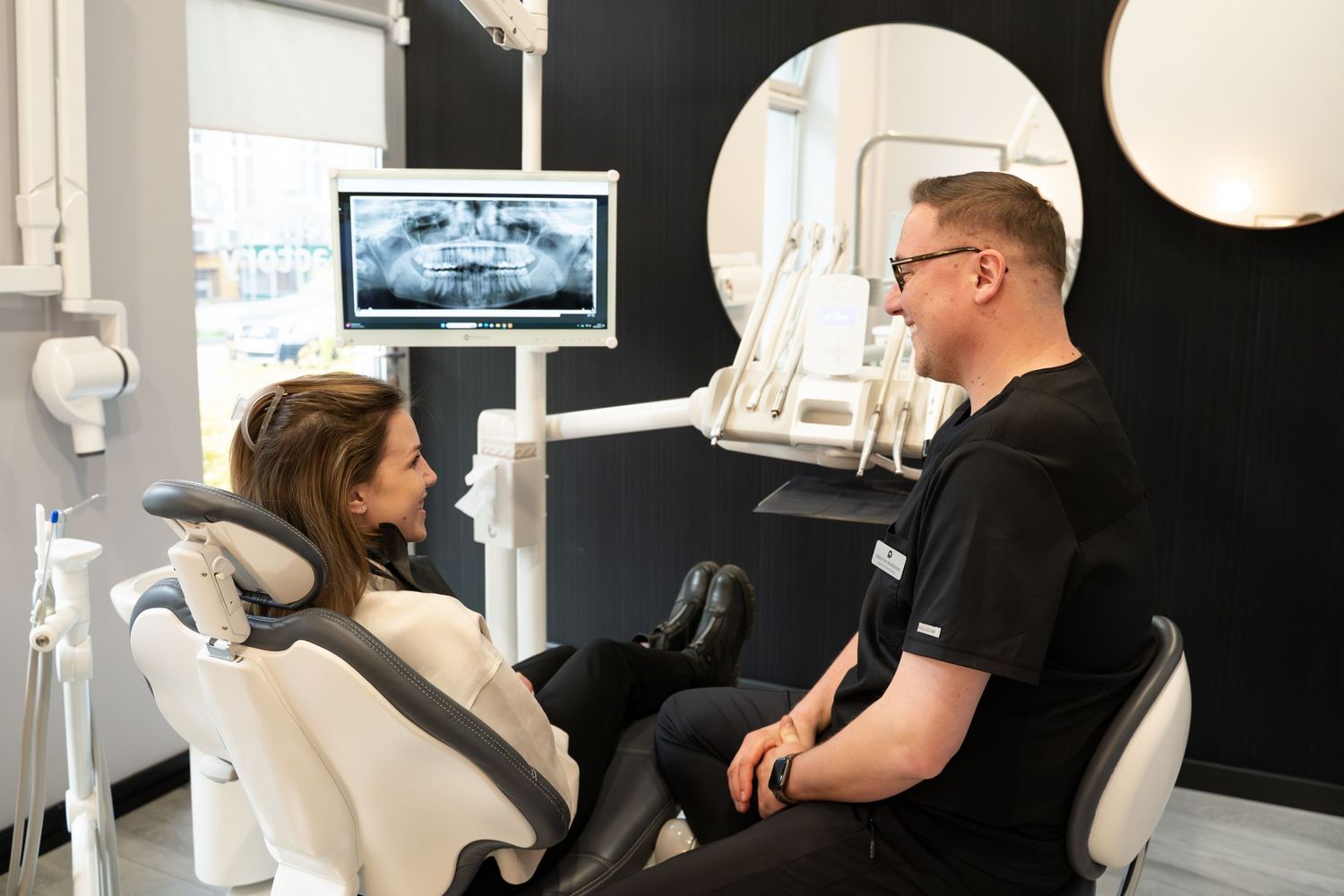 Dental consultation in modern office with equipment and monitor display.