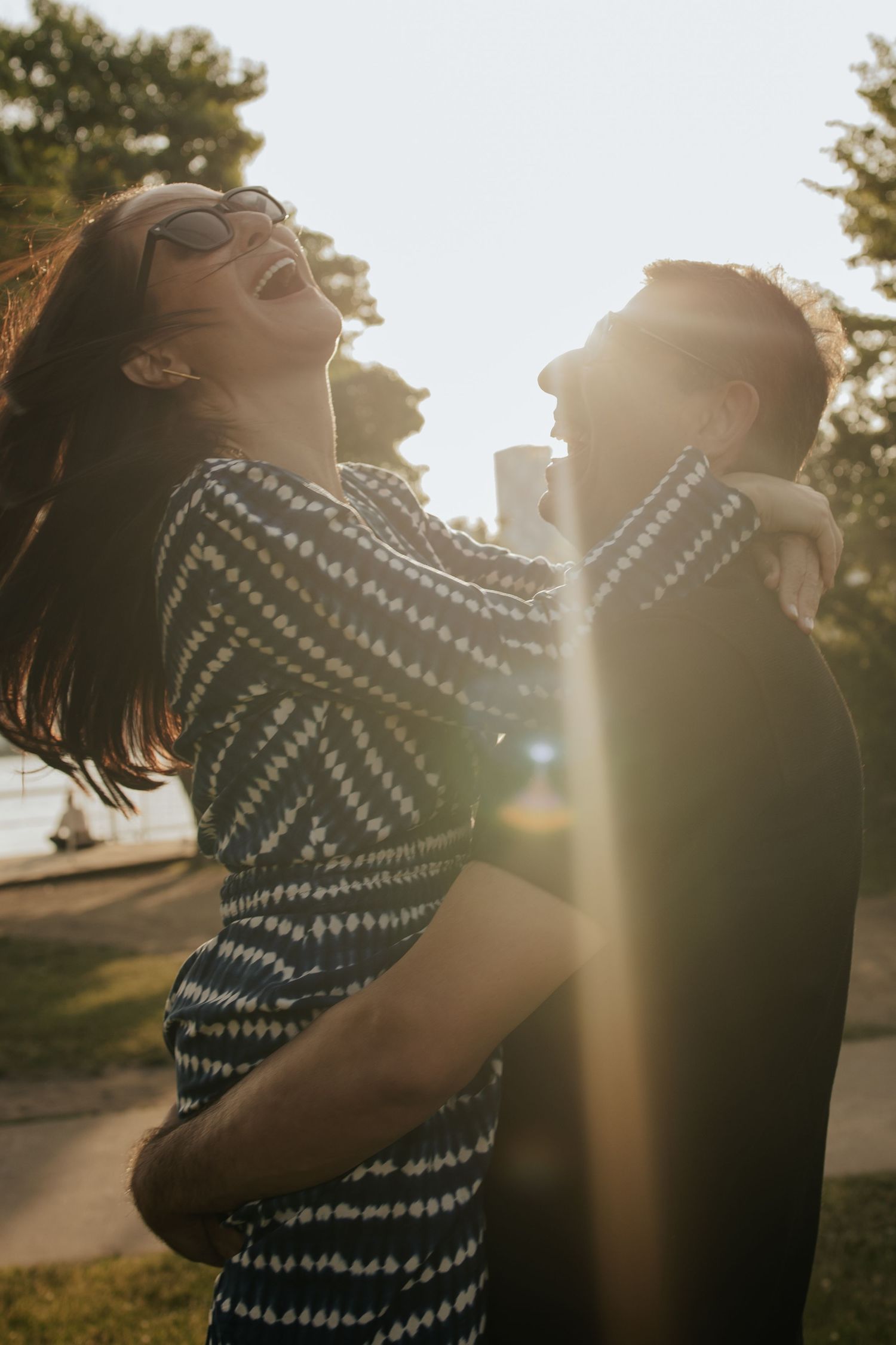 husband lifting his wife at the poison pier park, o the sunset and she is laughing out loud