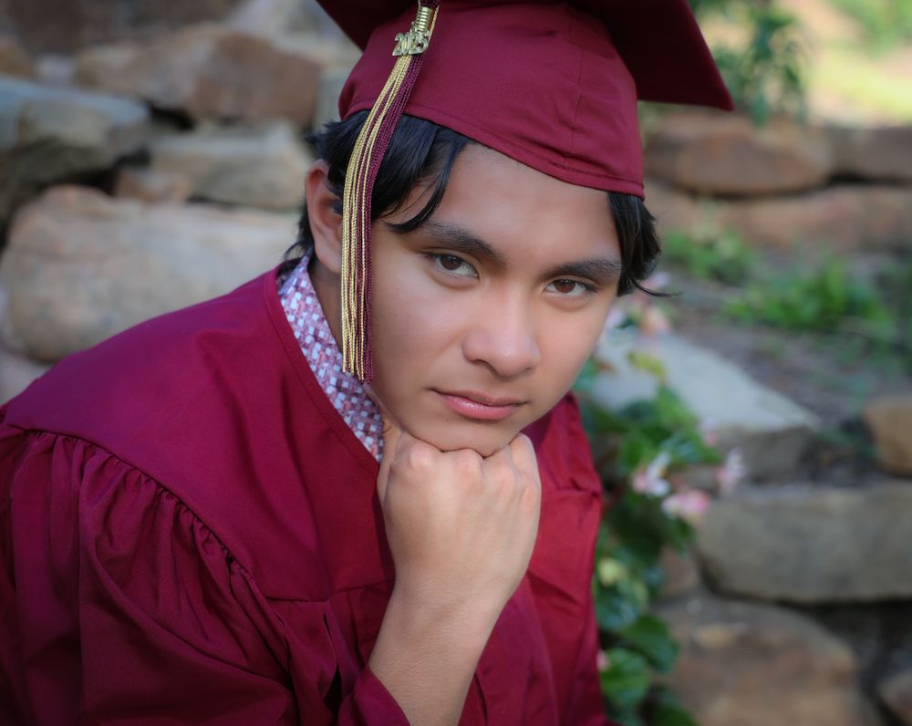Graduation portraits showing contemplative poses against natural background.