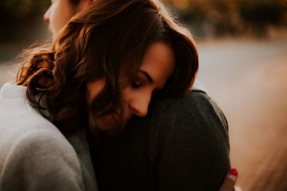 Romantic embrace captured in warm sunset lighting outdoors.