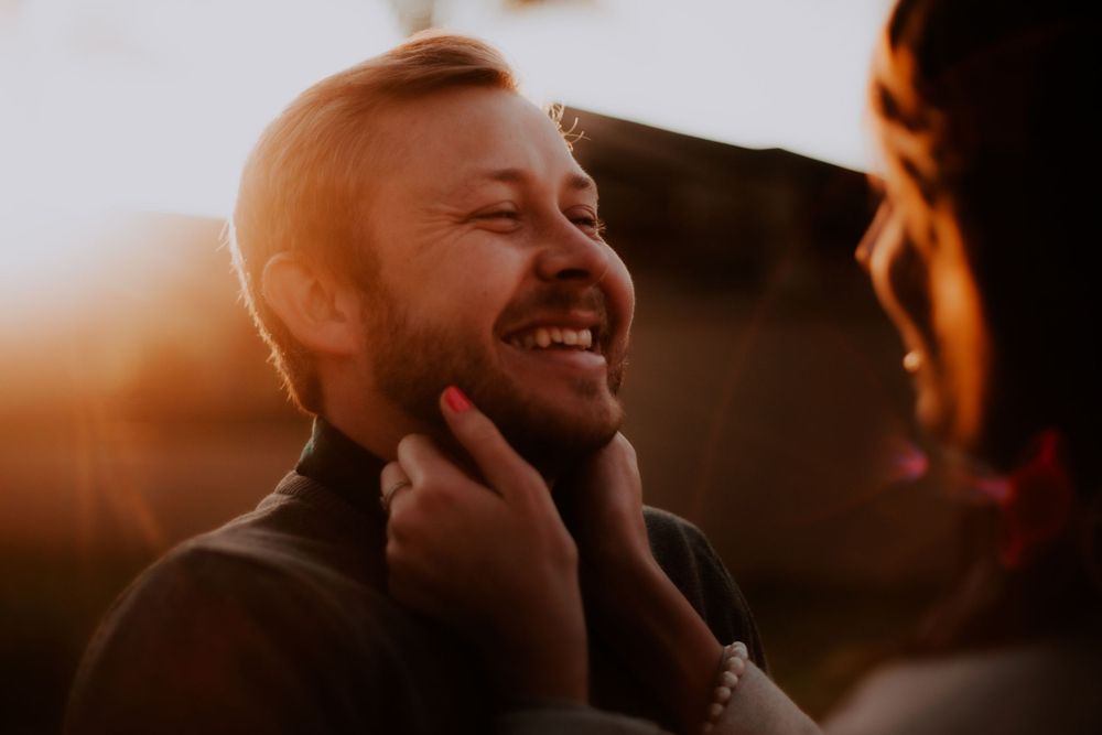 Joyful moment captured during sunset with genuine laughter and warmth.