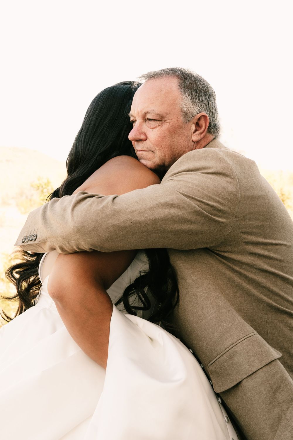 A sequence of warm embraces between wedding participants shown in golden light.