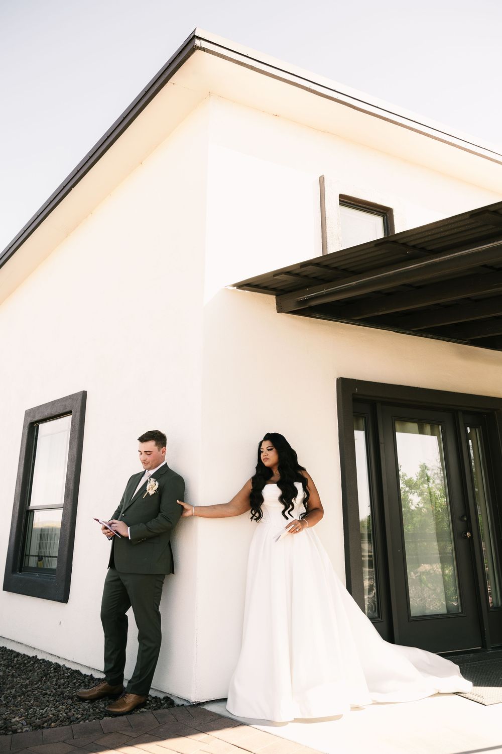A couple stands separated by a wall during their first look wedding moment.