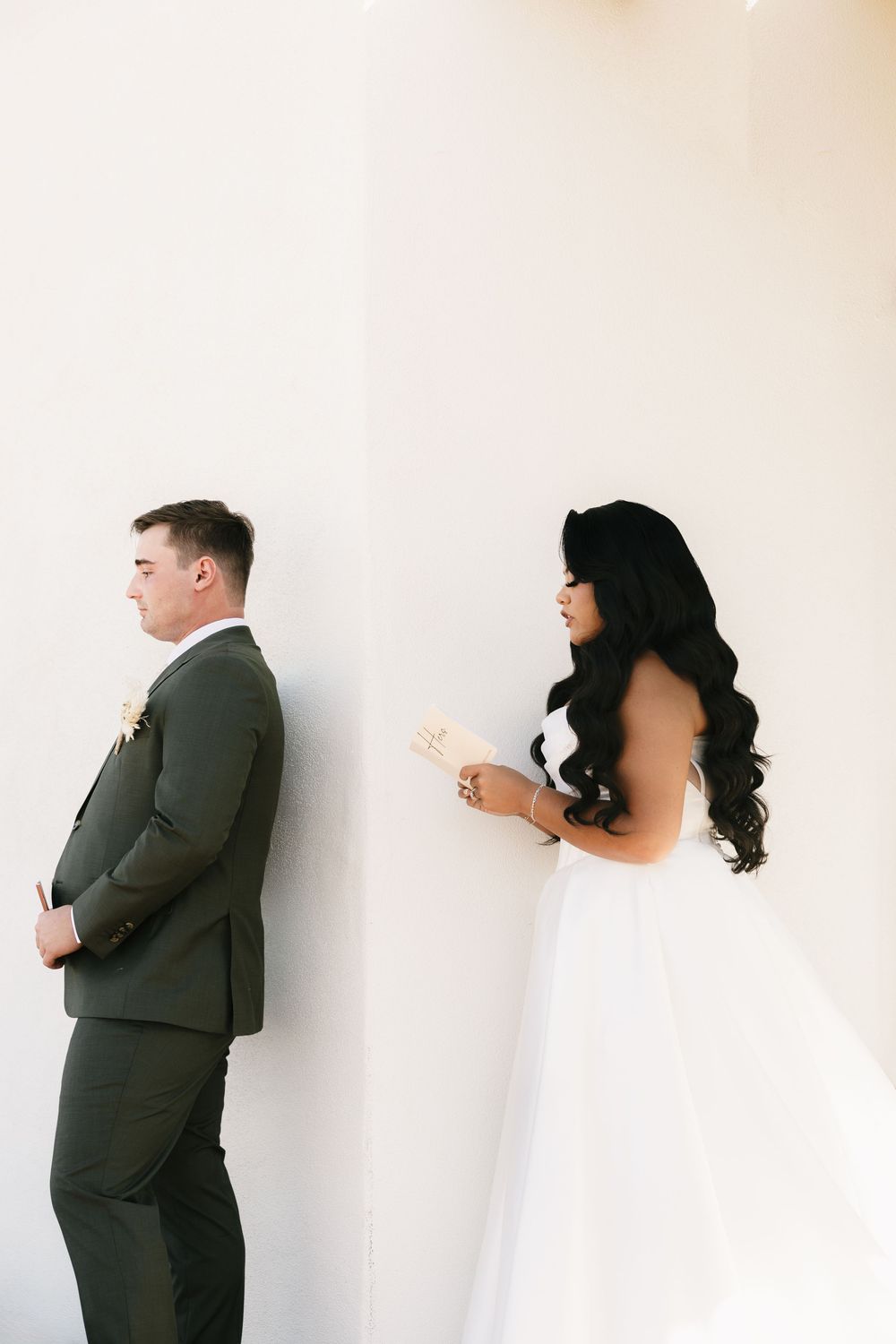Artistic sequence of couple playfully hiding behind white walls in a modern minimalist setting.