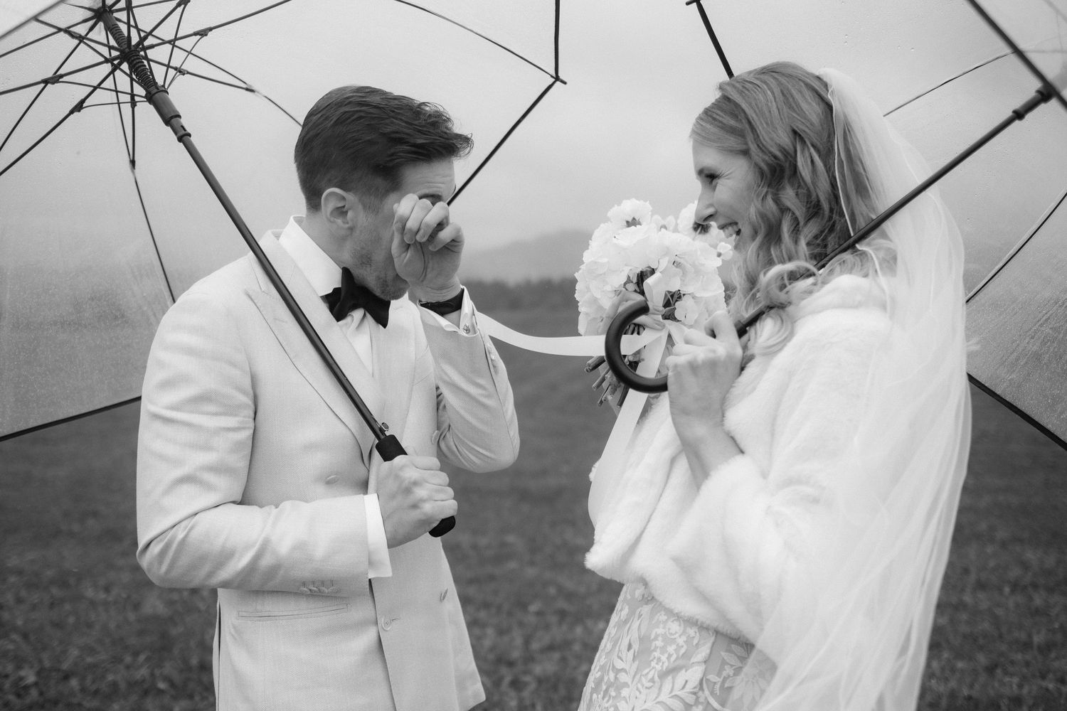 Emotionaler First Look bei Regen – Braut und Bräutigam mit Regenschirm kurz vor ihrer Hochzeit im Allgäu