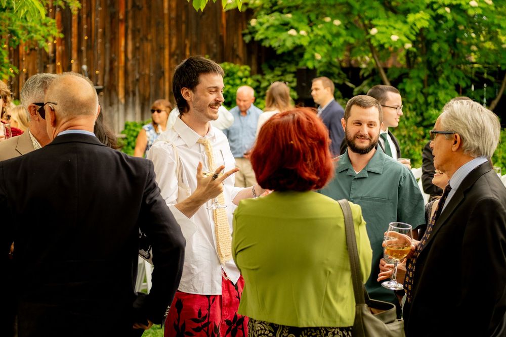 A lively outdoor gathering with guests mingling and chatting.