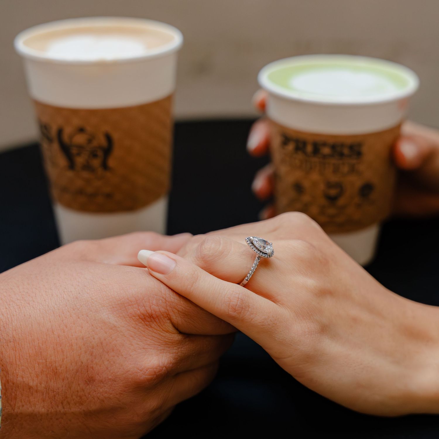 A couple holding hands on a coffee date in Press Coffee Broadway in San Antonio for a photoshoot with Caballero Creates.