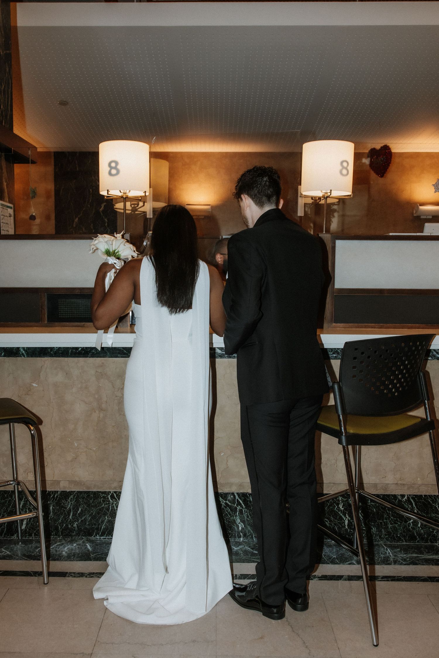 A couple seated at a modern bar counter in wedding attire, showing a series of casual moments.
