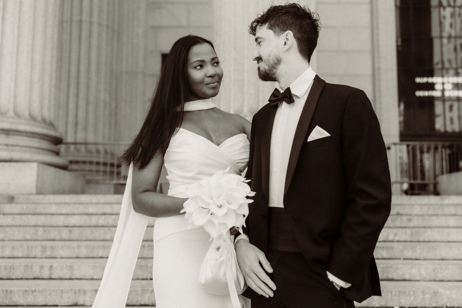 Classic black and white wedding portrait captured on grand stone steps.