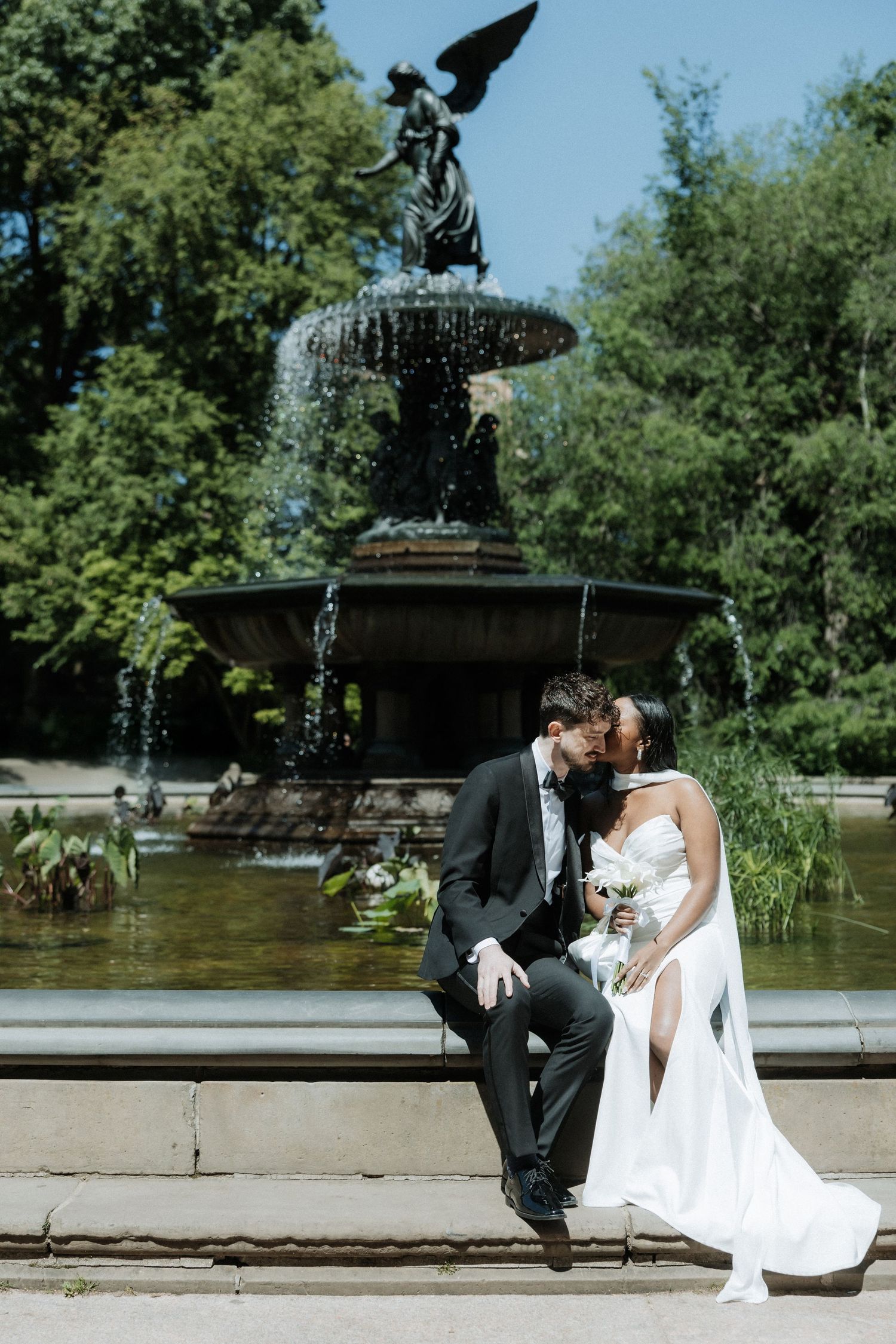 A newlywed couple posing by the historic Bethesda Fountain in Central Park.