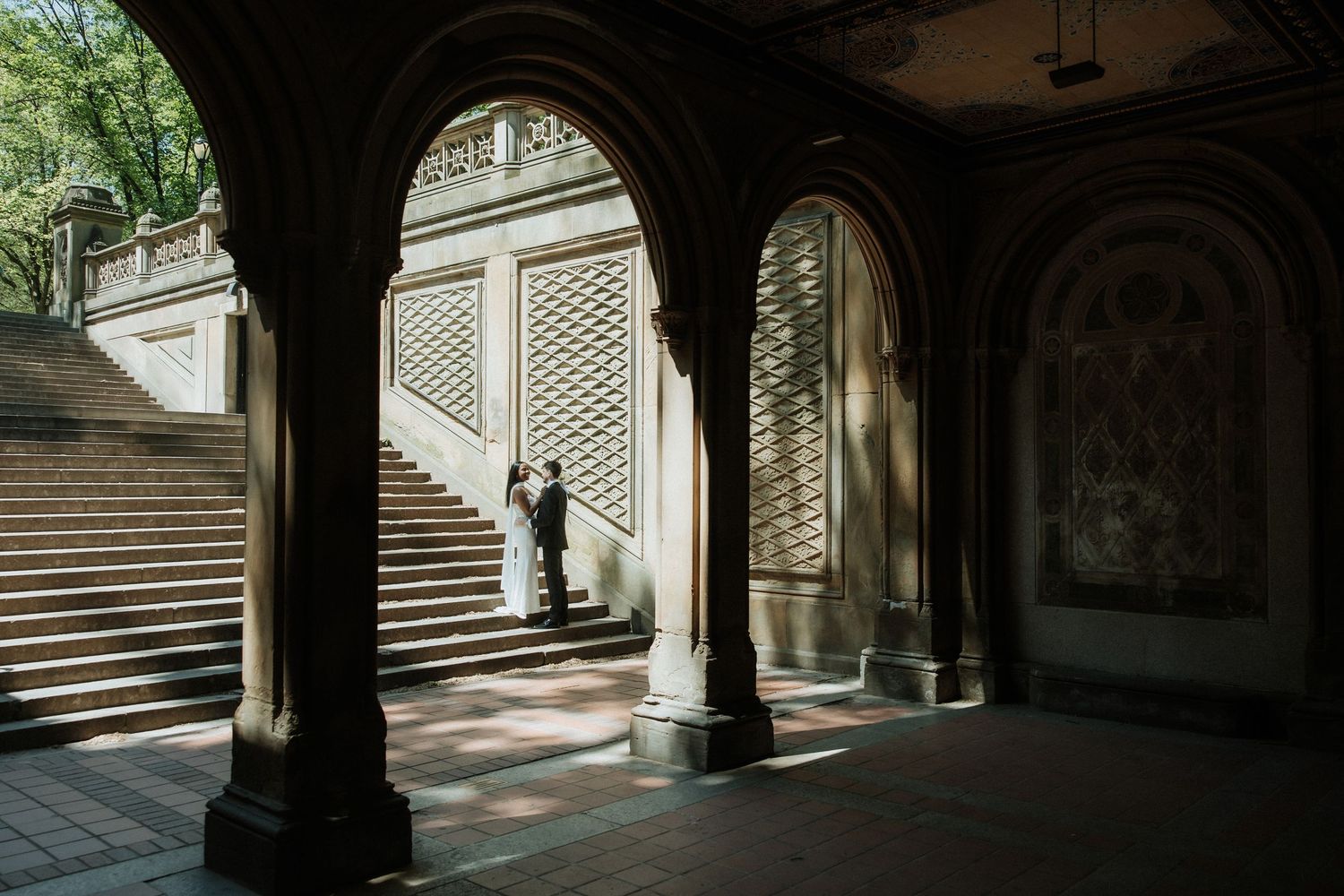 Wedding photos taken under ornate archways and columns of a classical building.