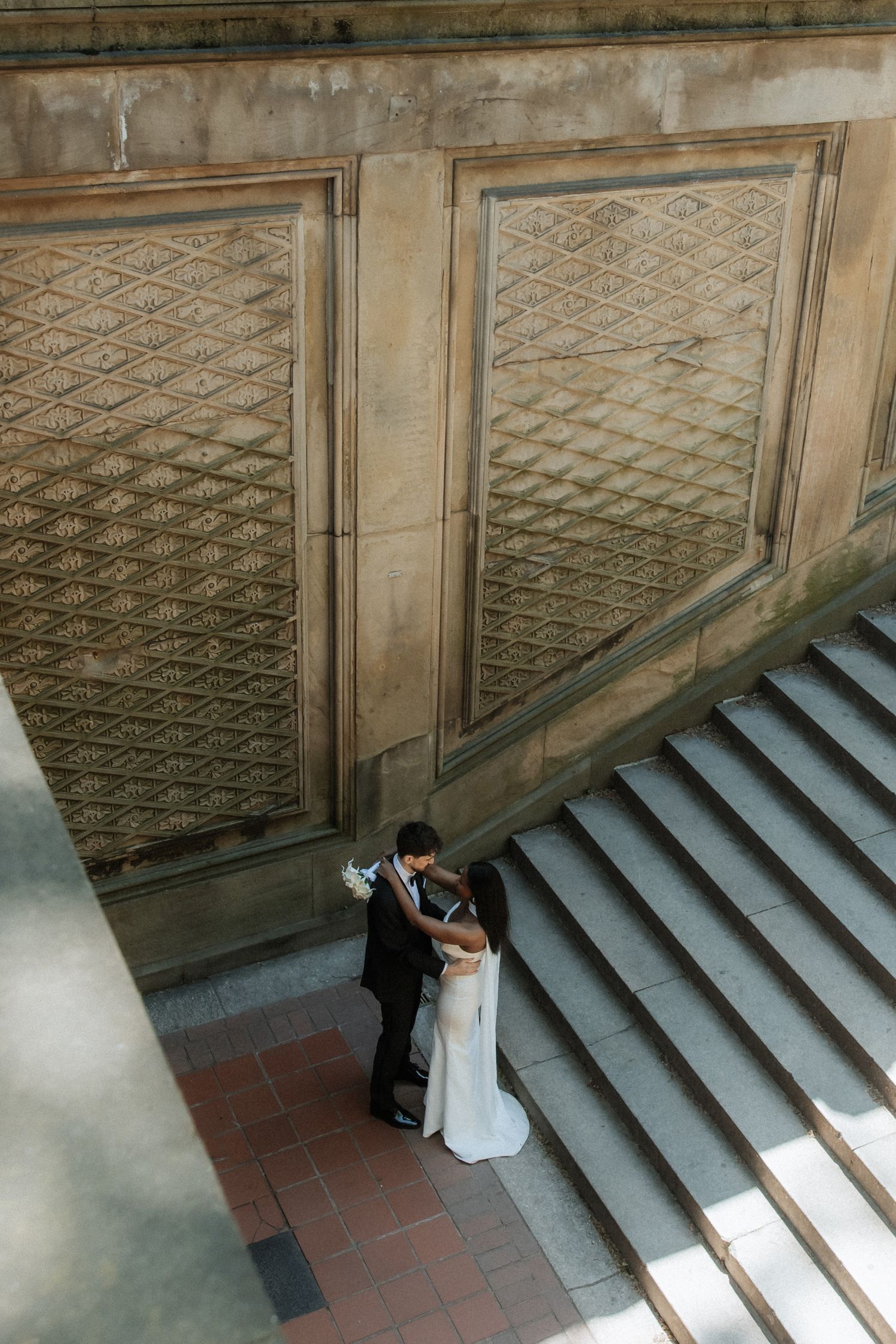 Wedding sequence showing couple on grand stone steps against a decorative wall.