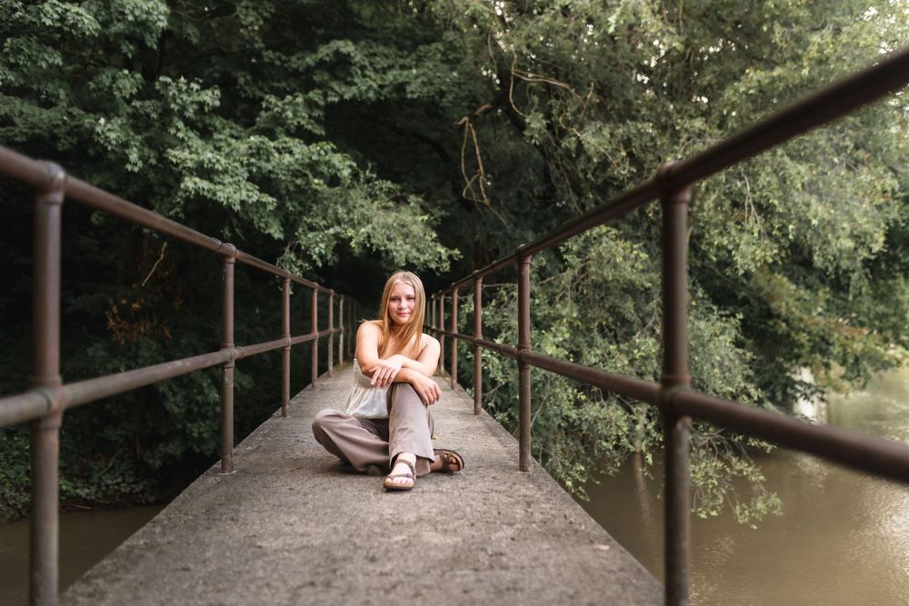 Portrait of a senior girl sitting on a bridge over the Grand River.