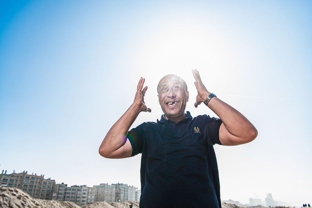 Outdoor portrait of a 'Chahed' screaming under a bright blue sky, part of a larger photo project on gambling addiction. By John Ferguson