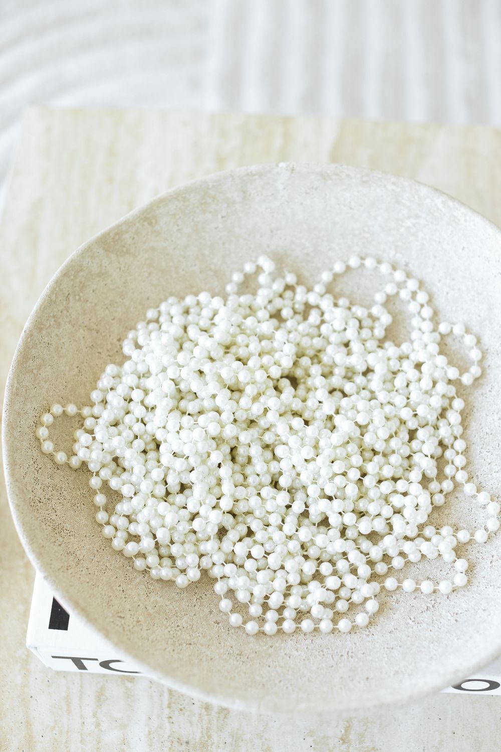 A sequence of dishes showing increasing amounts of small white pearls or beads arranged in piles.