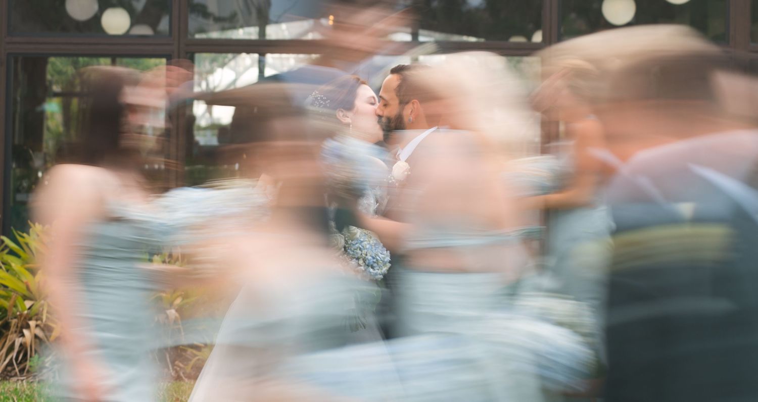 Motion-blurred portrait of wedding guests creating ethereal celebration atmosphere.