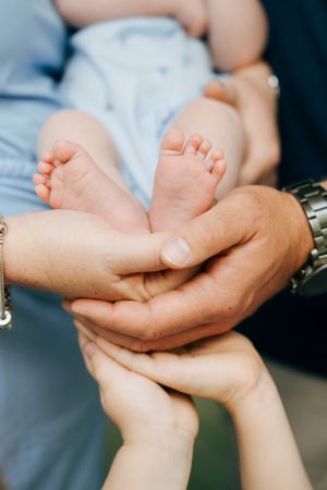 Close-up of small baby feet being gently held by adult hands.