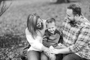 Black and white candid photo of family laughing together outdoors.