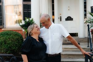 A couple shares a loving moment outdoors in black and white outfits.