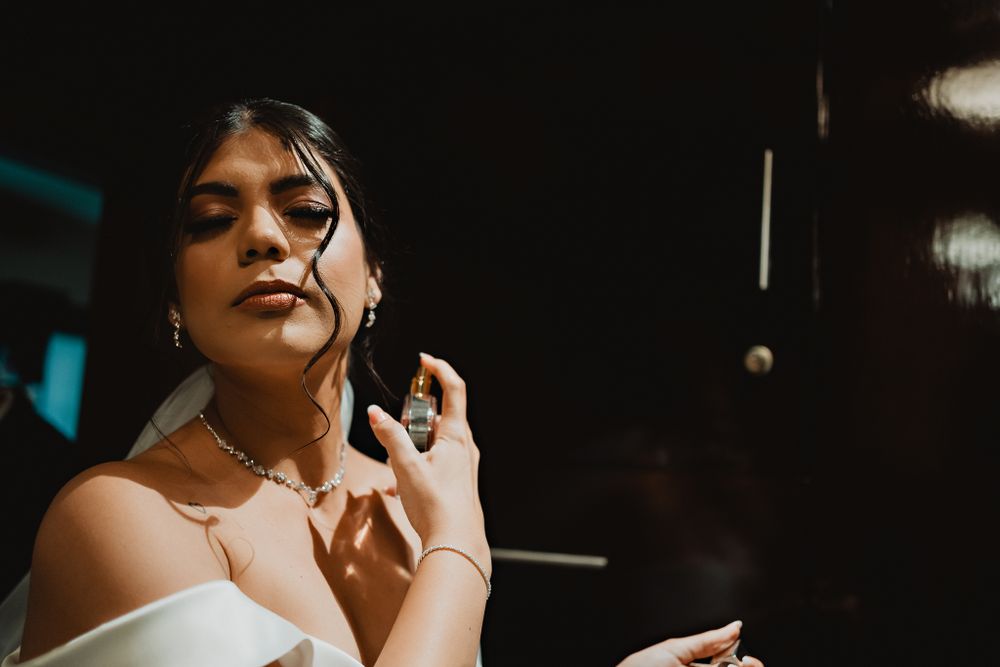 The bride applying perfume, a delicate and beautiful moment before the wedding