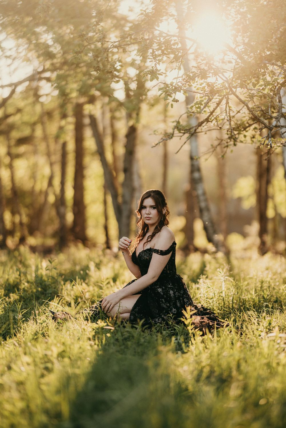 Ethereal golden sunlight filters through trees in a dreamy spring meadow setting.