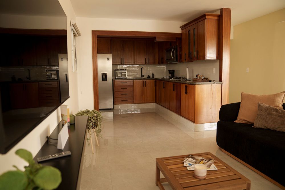 Large kitchen and living space with wood cabinets and modern appliances.