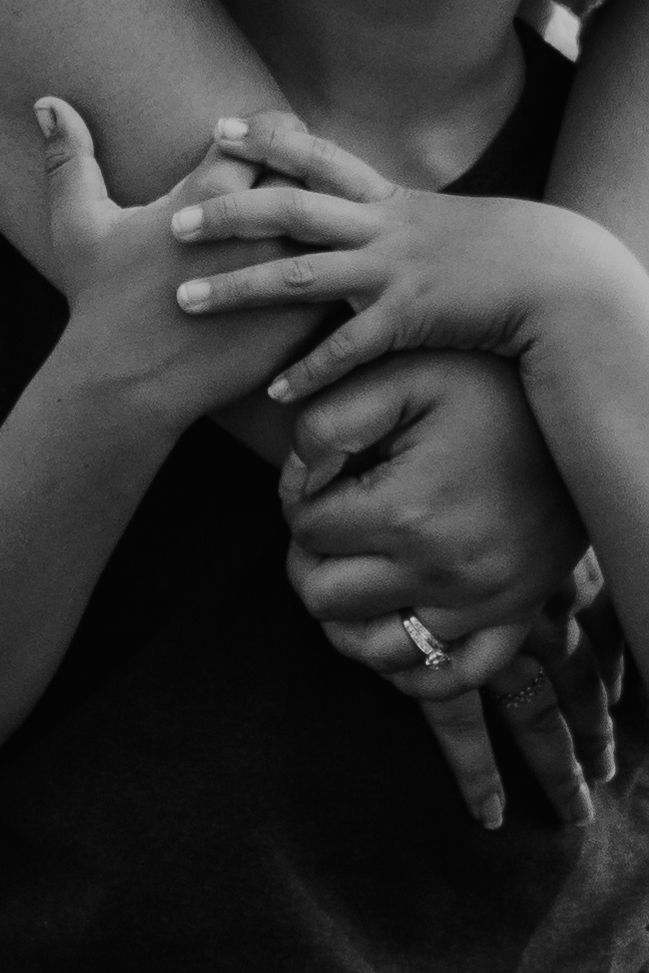 Black and white photo. Close up of a mother and son's hands