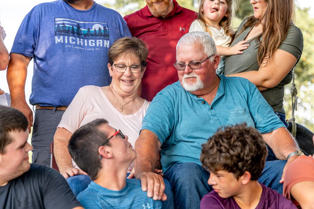 A multi-generational family gathering shows warm interactions between people wearing casual attire.
