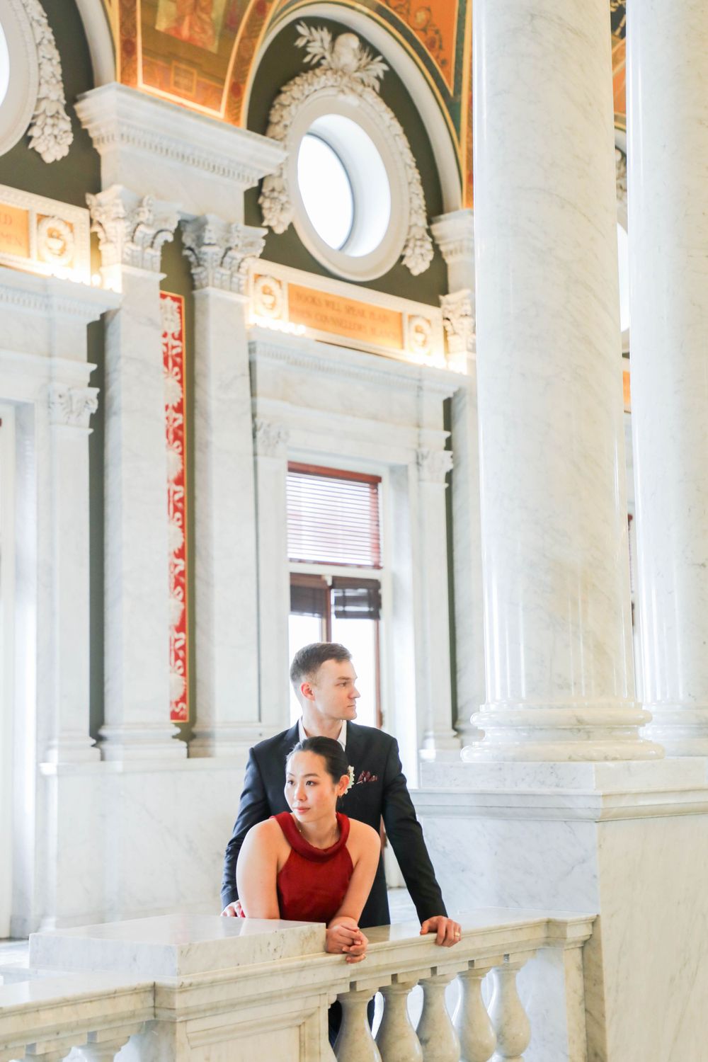 Elegant marble interior with ornate classical columns, arched windows and decorative architectural details in a historic building.