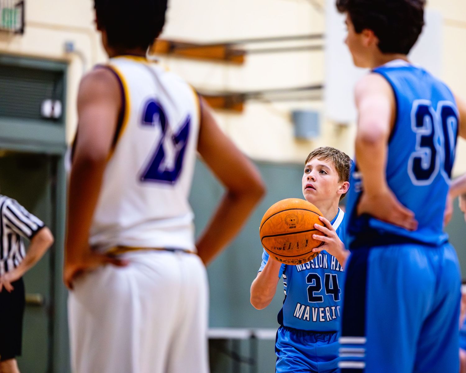 Basketball player in blue jersey preparing to shoot free throw during game.