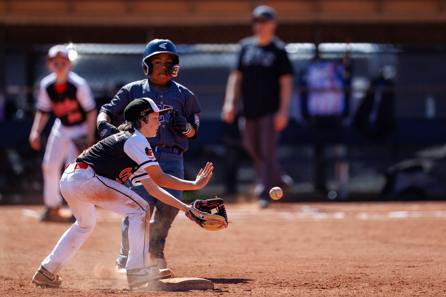 Baseball players from opposing teams in action on a dusty infield during a game.