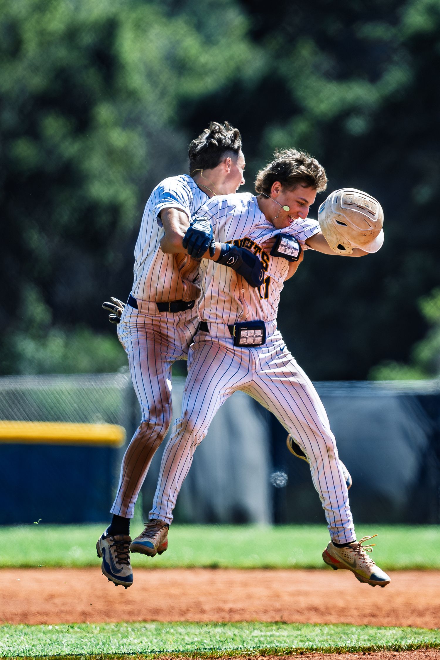 Two baseball players in pinstripes collide while jumping for a catch.
