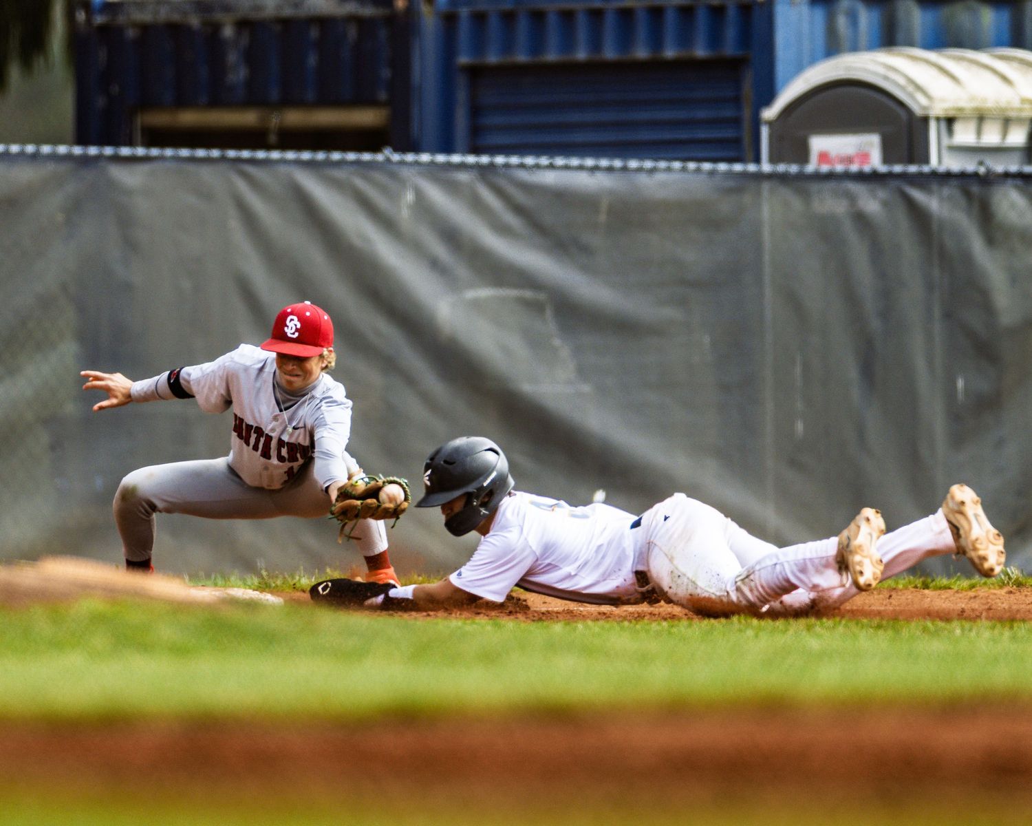 Close play at second base as fielder attempts to tag sliding baserunner.