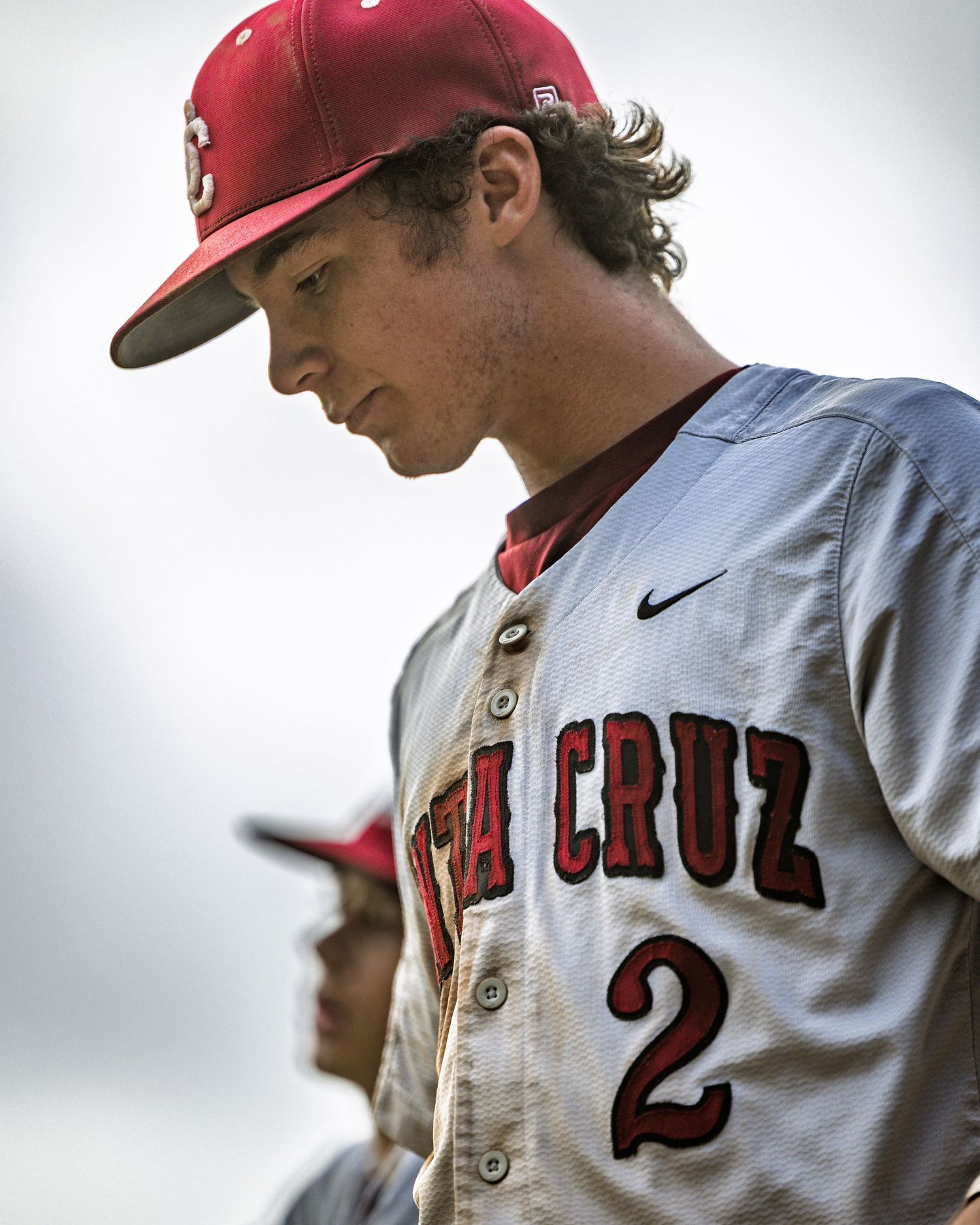 Baseball player in red cap and Santa Cruz uniform during game.