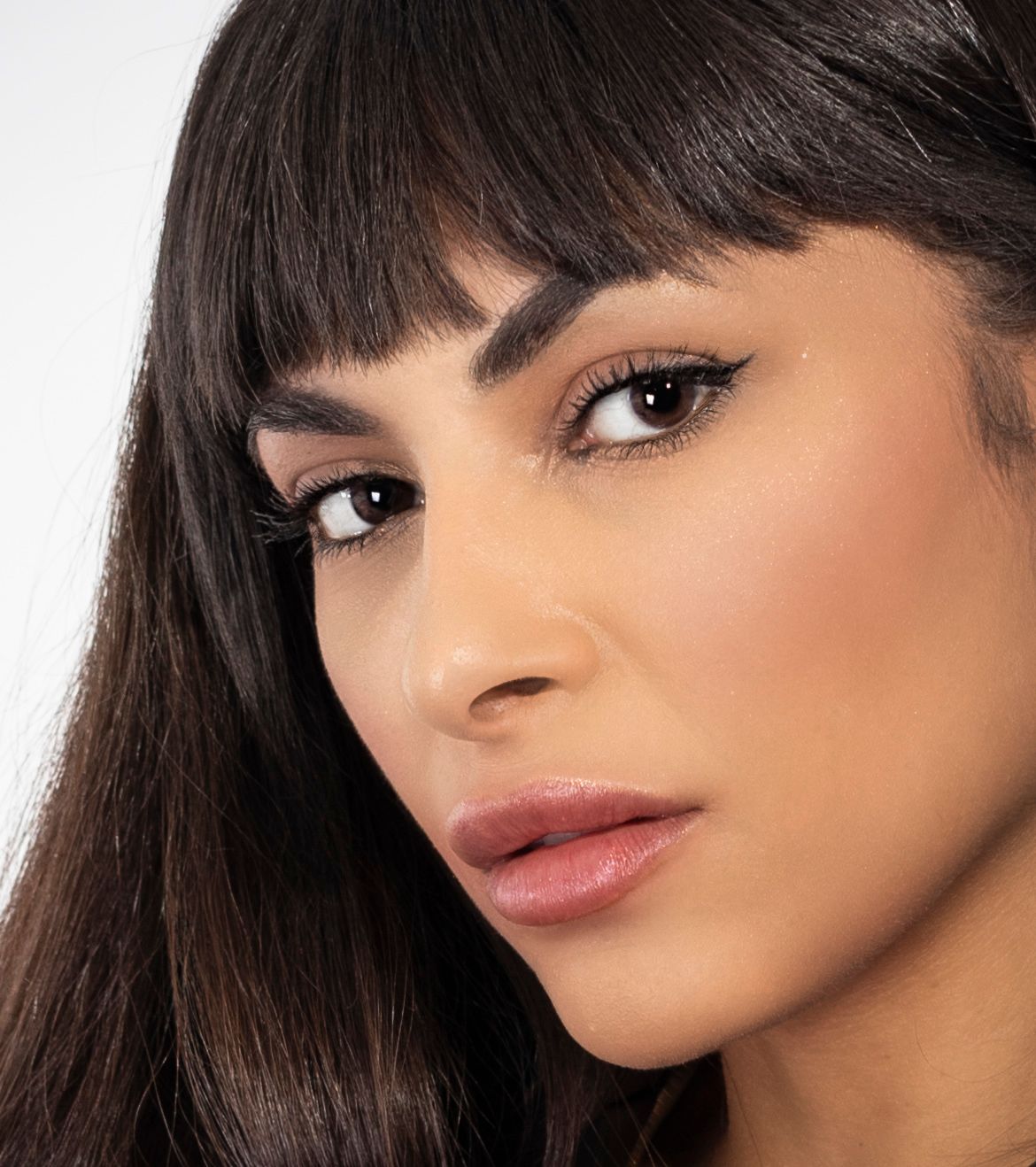 Beauty portrait featuring flawless makeup and long dark hair with bangs. Best portrait photographer