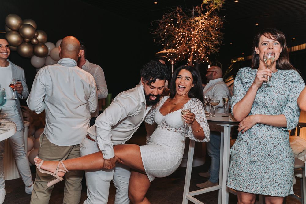 Wedding party guests dancing and having fun at an outdoor reception celebration with sparklers in the background.