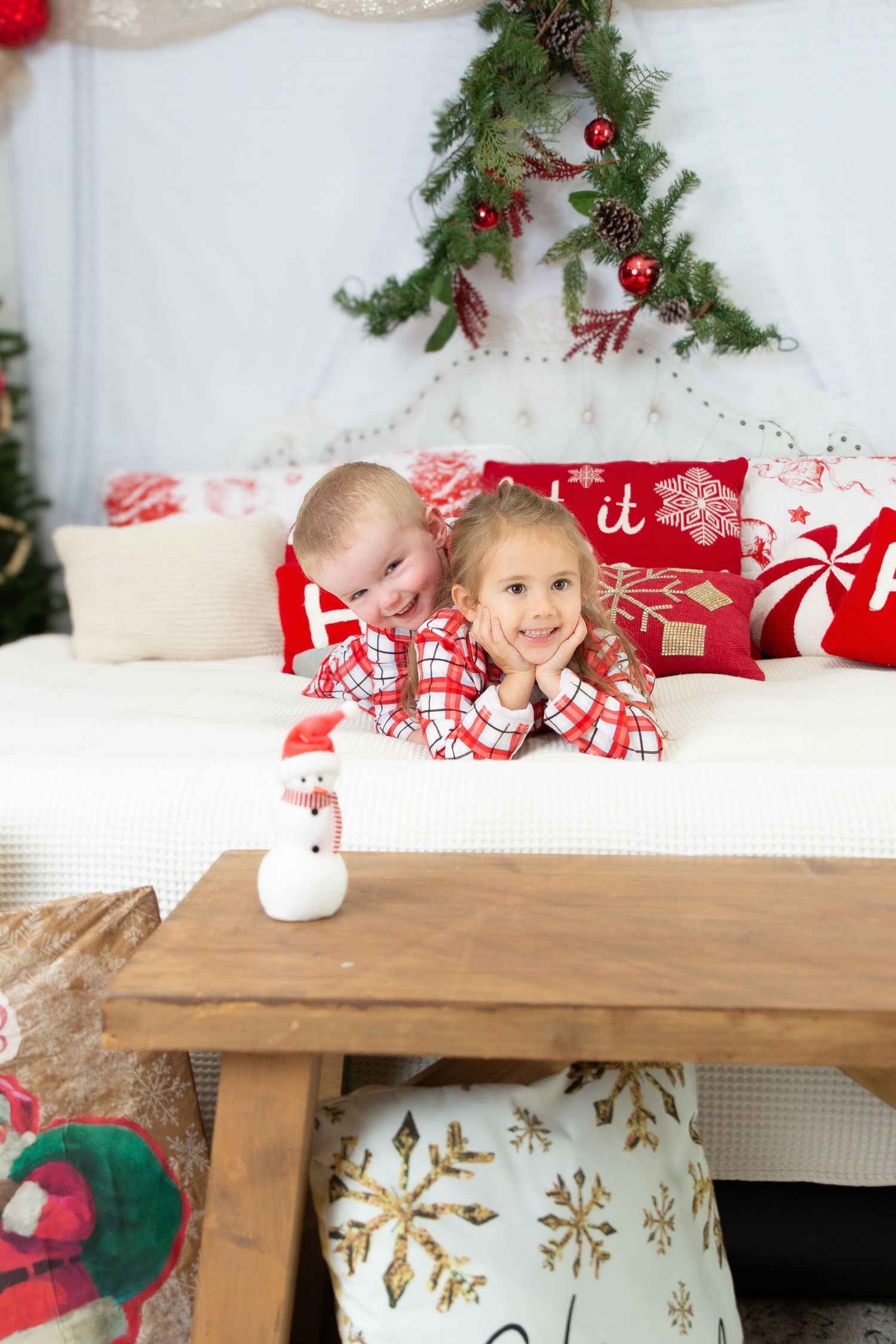 Christmas themed photo with matching red plaid pajamas and festive decorations.