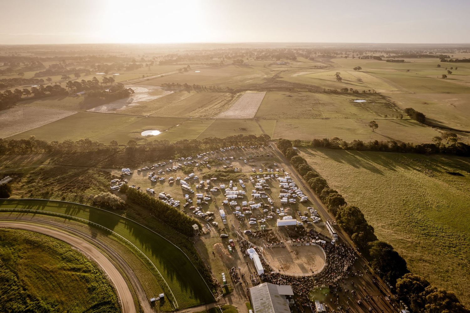 Aerial panoramic view of a rural town nestled against dramatic mountain cliffs. Hamilton Rodeo.
