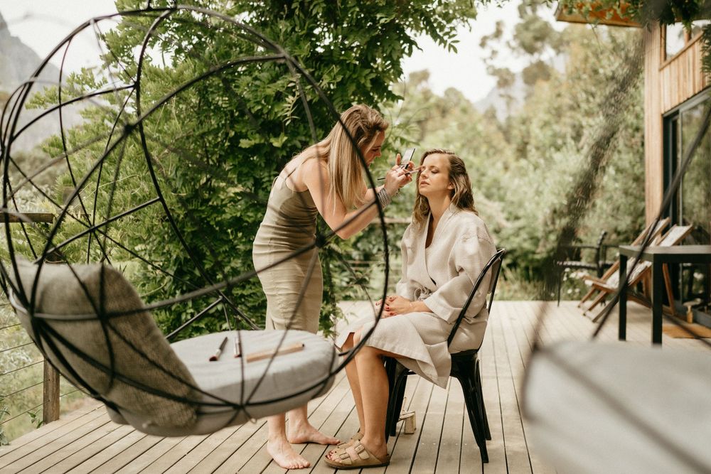 A couple sharing a joyful moment together on a wooden deck surrounded by greenery and natural light.