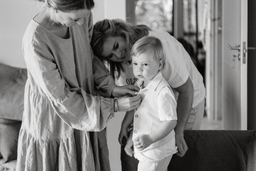A tender black and white moment of family members interacting indoors.