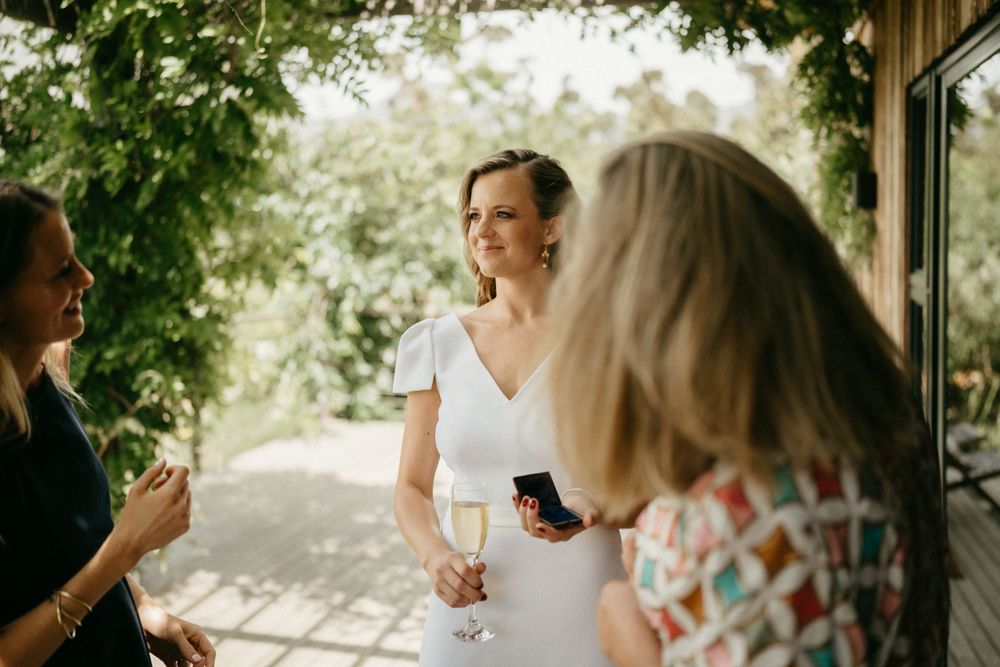 Guests enjoying drinks and conversation at an outdoor garden reception.