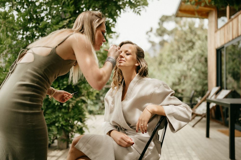 Two guests laugh and smile together during an outdoor wedding celebration event.